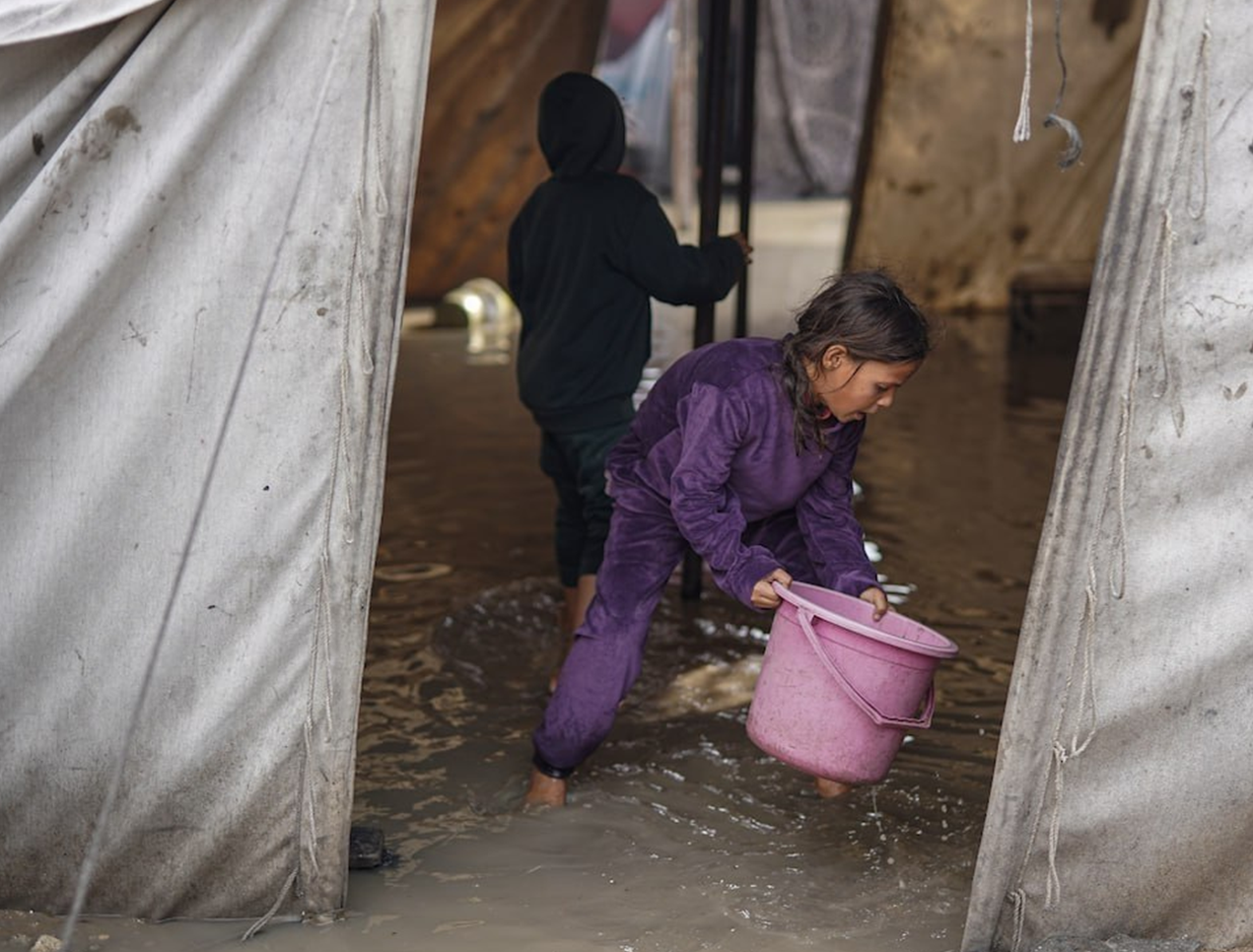 مردم غزه با سطل آب را از چادر بیرون میریزند